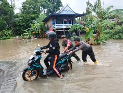 Sinergitas Babinsa Kodim 1404/Pinrang Dan Bhabinkamtibmas Membantu Pengendara Roda Dua Melintasi Jalan Yang Terendam Banjir